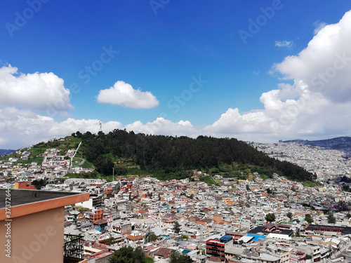 View of the center of the city of Quito and El Panecillo hill, observing their houses and the forest around the mountain