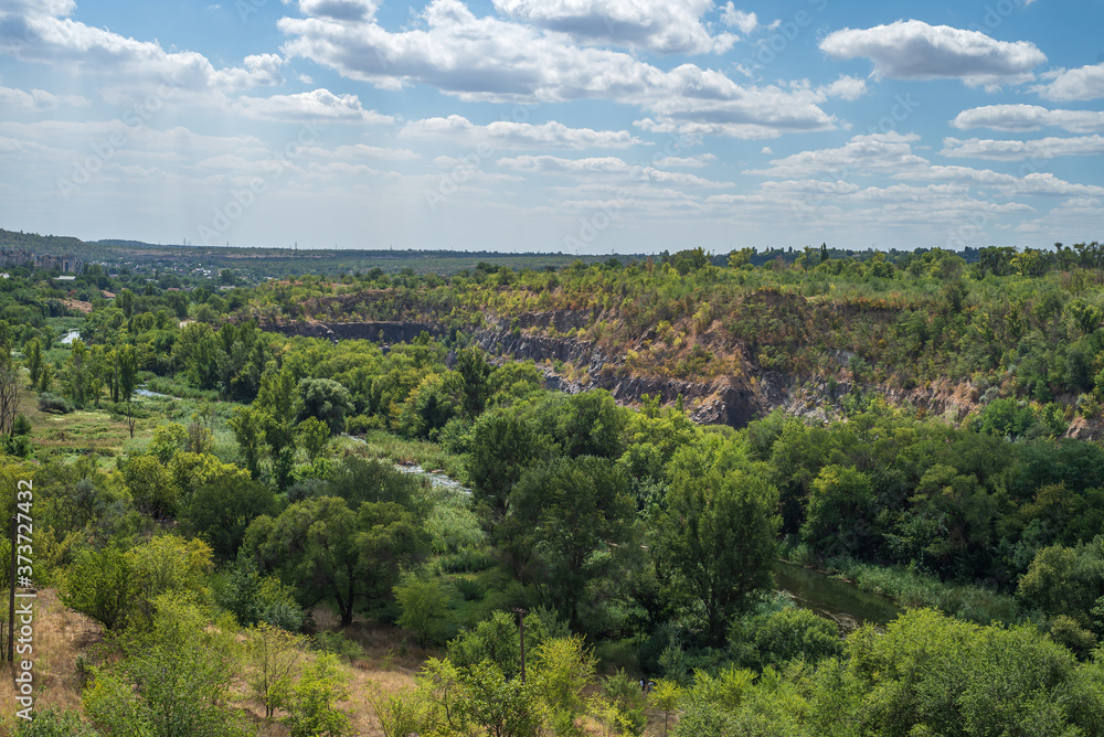 Granite quarry in a steppe landscape. Karachunovsky granite quarry on the outskirts of the city of Kryvyi Rih near the reservoir of the Ingulets river.