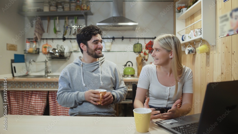 Happy couple having breakfast. Young man brings coffee to his girlfriend or wife Happy couple having breakfast. Young man brings coffee to his girlfriend or wife