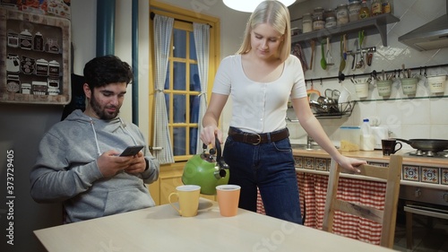 Young couple drinking tea together on a kitchen