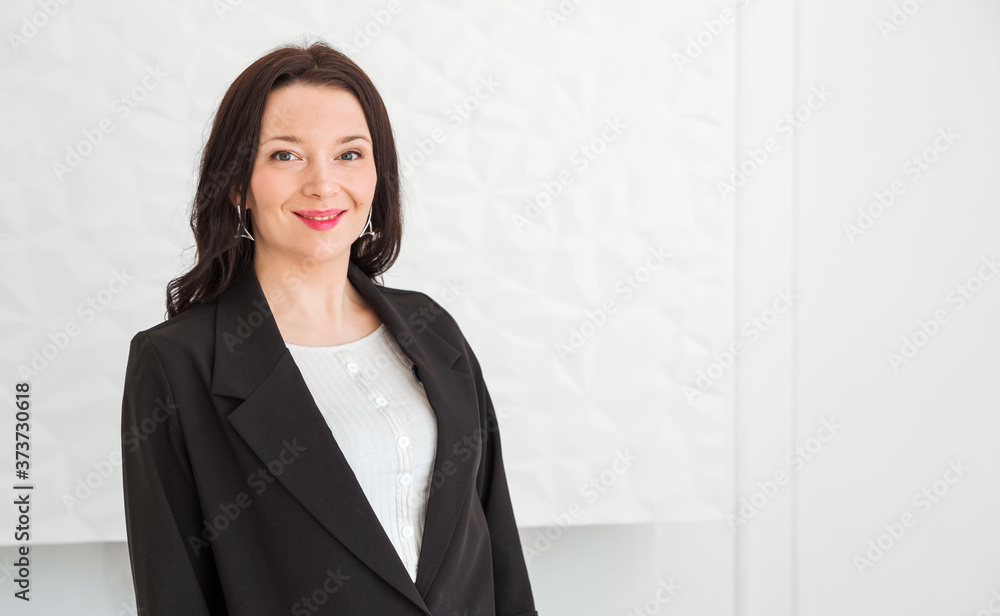 Fashionable brunette girl in a black jacket posing on a white background. Girl looking at the camera and smiling Fashionable brunette girl in a black jacket posing on a white background. Girl looking at the camera and smiling