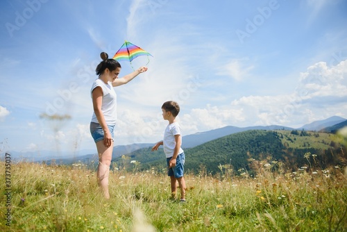Little boy flies a kite into the blue sky