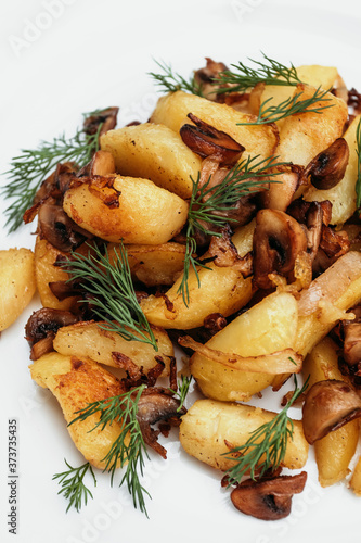 Fried potatoes with mushrooms on white plate.
