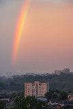 Rainbow over the city sunset