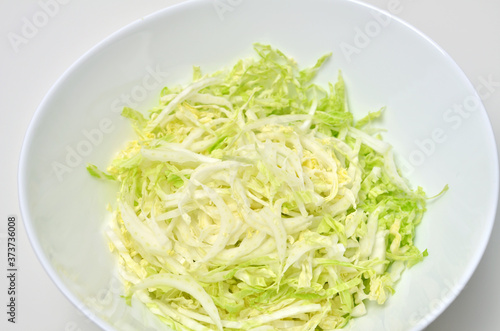 Napa cabbage salad in bowl on white background. Vegan food.