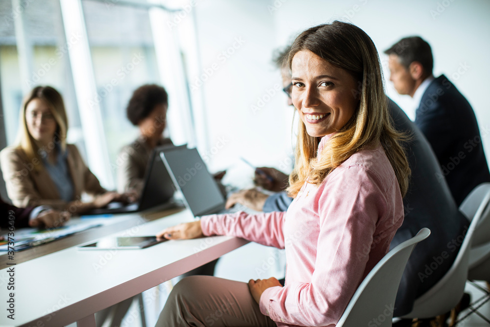 Young woman smiling during successful business meeting in the modern office