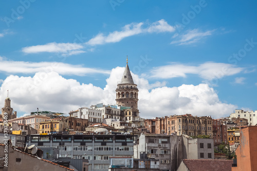 The Galata Tower and old buildings of Beyoglu on a cloudy summer day, one of the main landmarks of Istanbul, Turkey