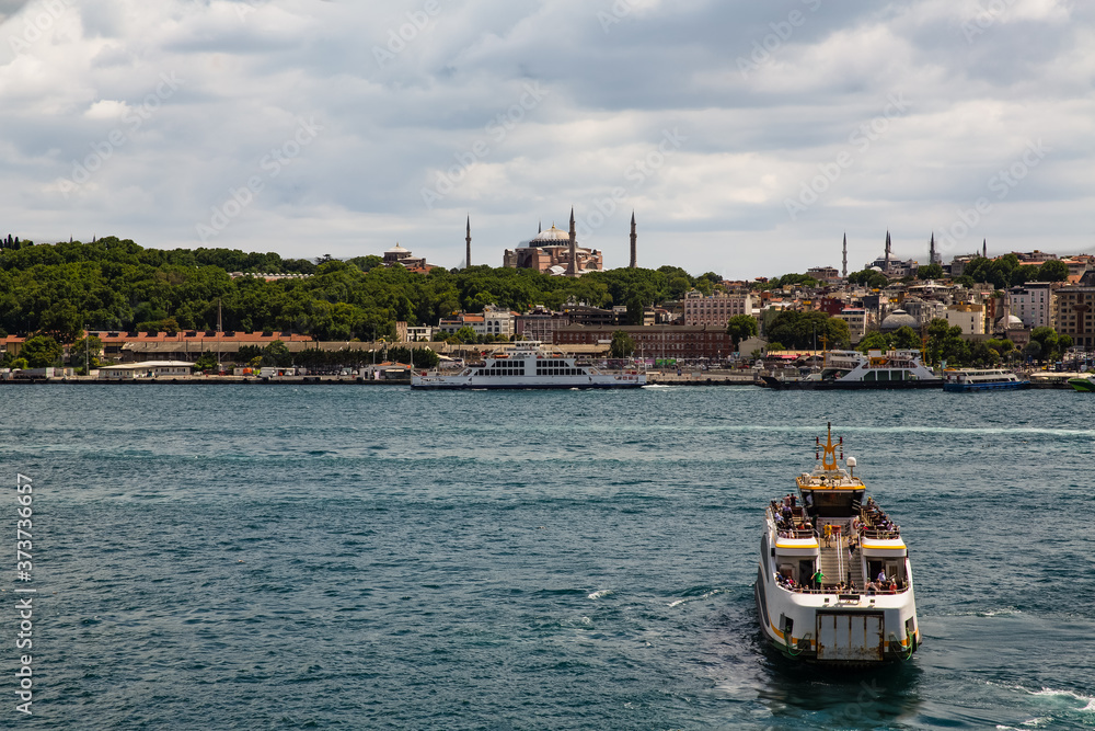 Panoramic shot of the old town Istanbul; The Hagia Sophia (Ayasofya) Mosque Eminonu, ferries and boats on the Golden Horn, Istanbul, Turkey.