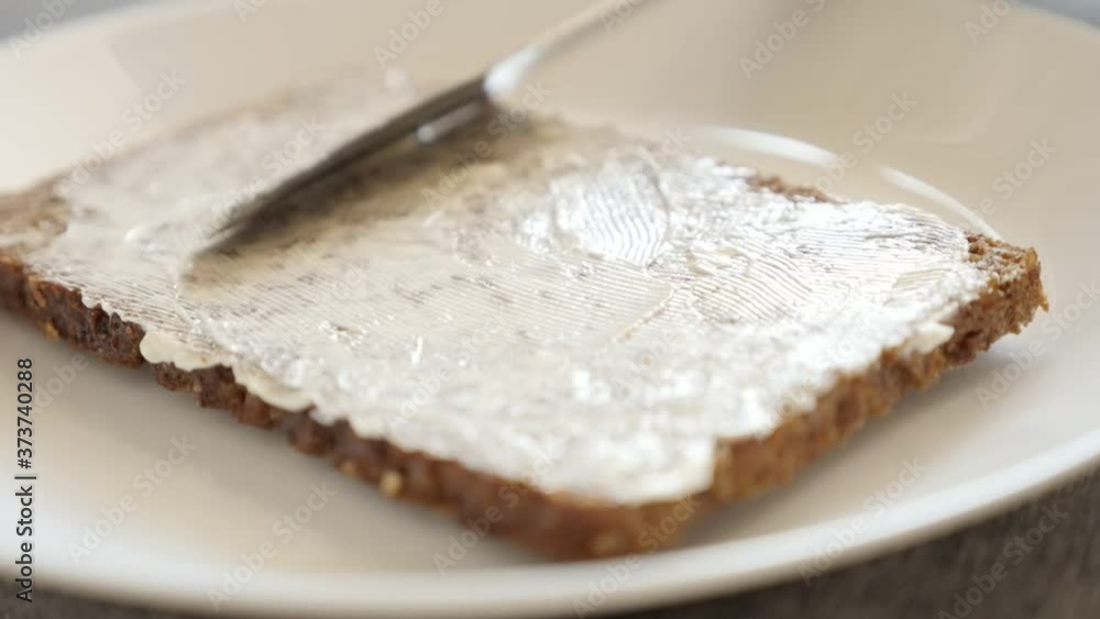 Slow motion knife spreading butter over the bread surface close-up video Slow motion knife spreading butter over the bread surface close-up video