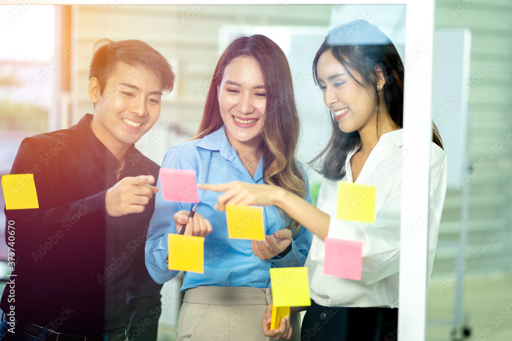 Group of young Asian business colleagues in team casual discussion, Start up partners are working in casual clothes, happy women having friendly conversation about business information having meeting.