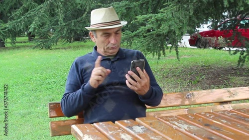 Middle Age Man Negating Something During Smartphone Conversation Over the Internet