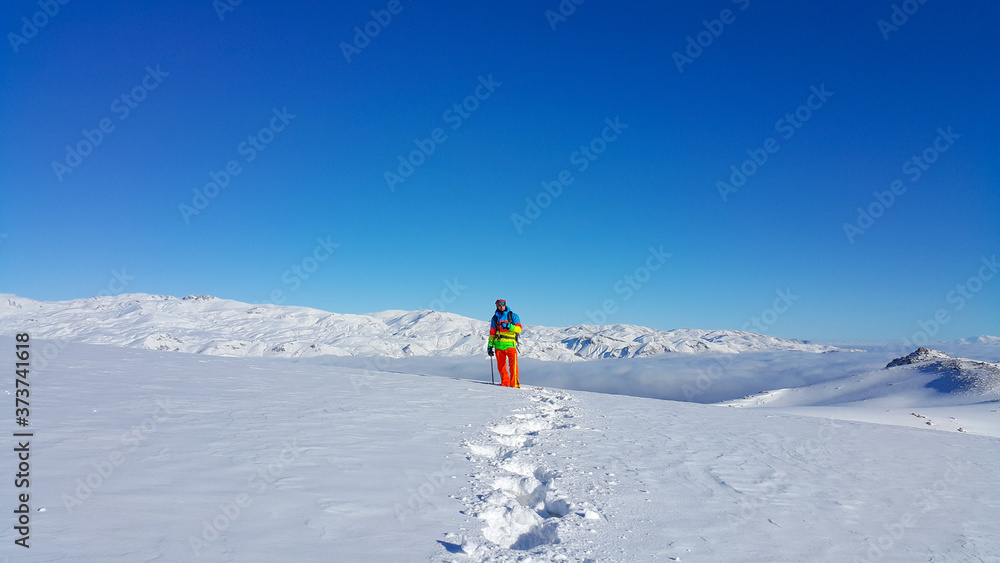 A skier and mountaineer in the snowy mountains, winter season

