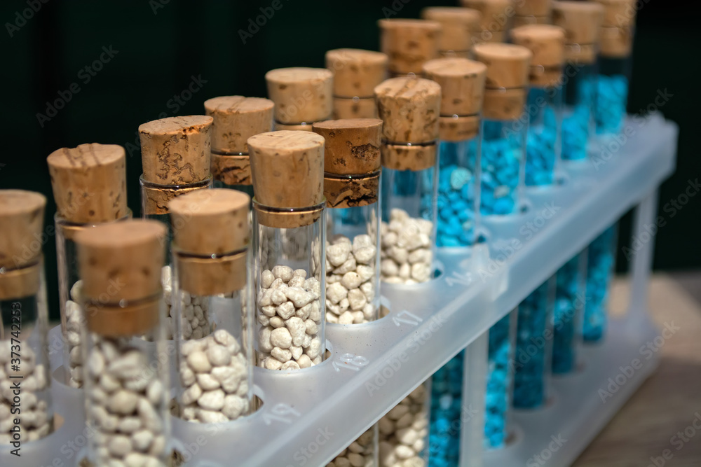 multi-colored granules of micronutrient fertilizer in test tubes in a row multi-colored granules of micronutrient fertilizer in test tubes in a row