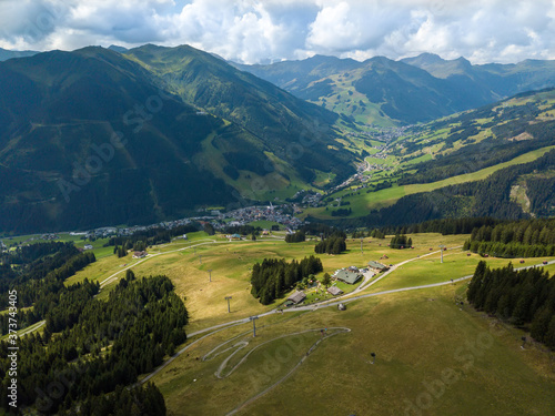 Aerial view on the Saalbach skiing region in Austria with mountainbike trails and hikers with great mountain panorama in the background.