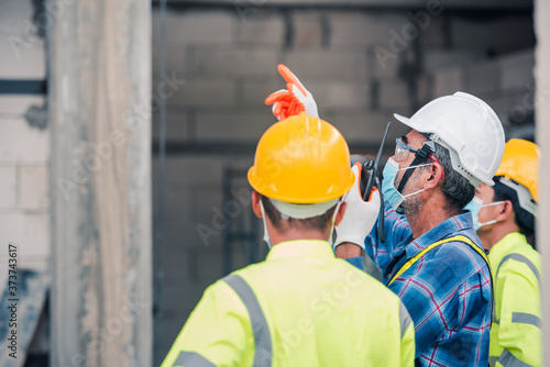 Engineers and construction workers wore a mask to prevent the Coronavirus (COVID-19) during construction using a construction site radio.