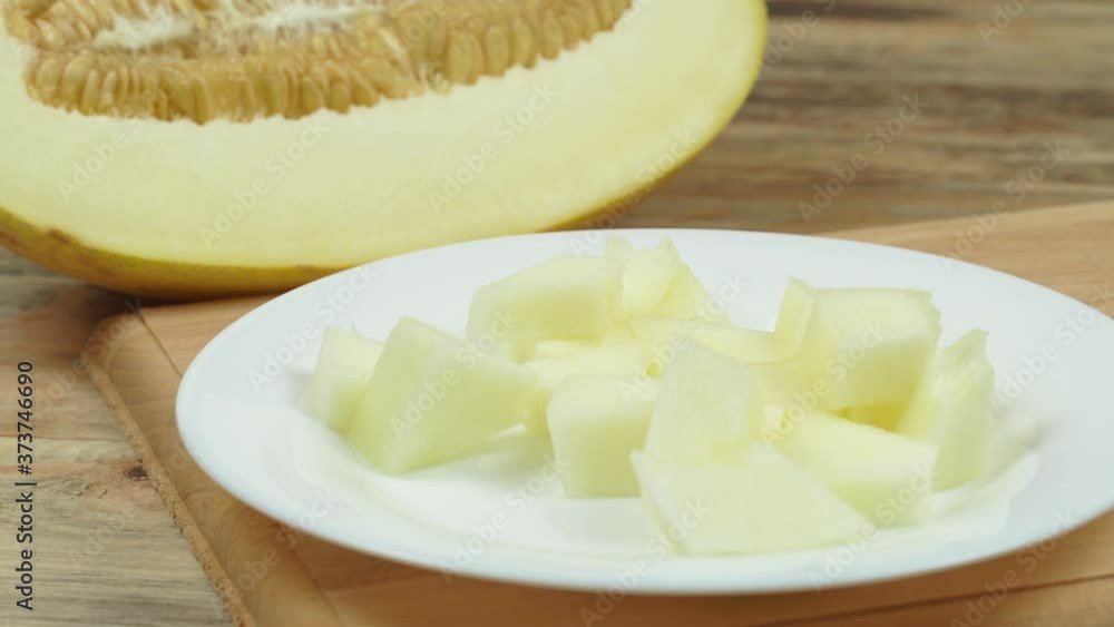 slices of delicious melon are on a white plate, pricked with a fork and eaten. slices of delicious melon are on a white plate, pricked with a fork and eaten.