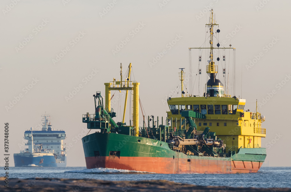 HOPPER DREDGER - A specialized vessel travels on a waterway at sea
