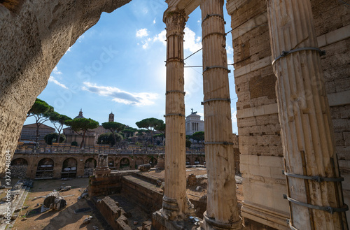 View from the Suburra of the Roman Augusto Forum in Rome Italy. Remains of the columns of the Imperial Forum of the Emperor Augustus on a summer day of sun and clouds. In the distance the forum of the photo