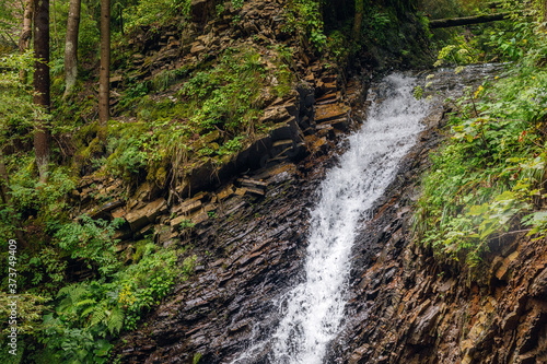 Waterfall in the forest in the highlands .