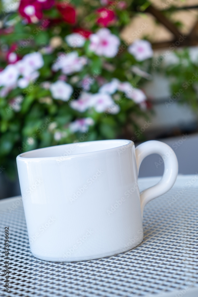 Coffee cup mockup on a table, blur green background. Coffee cup mockup on a table, blur green background.