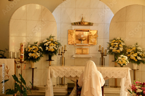 фотографія Nun kneeling in adoration of the Blessed Sacrament