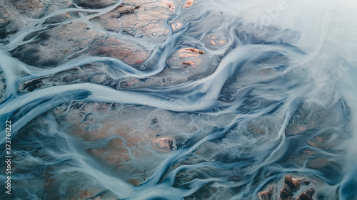 A glacial rivers from above. Aerial photograph of the river streams from Icelandic glaciers. Beautiful art of the Mother nature created in Iceland. Wallpaper background high quality photo