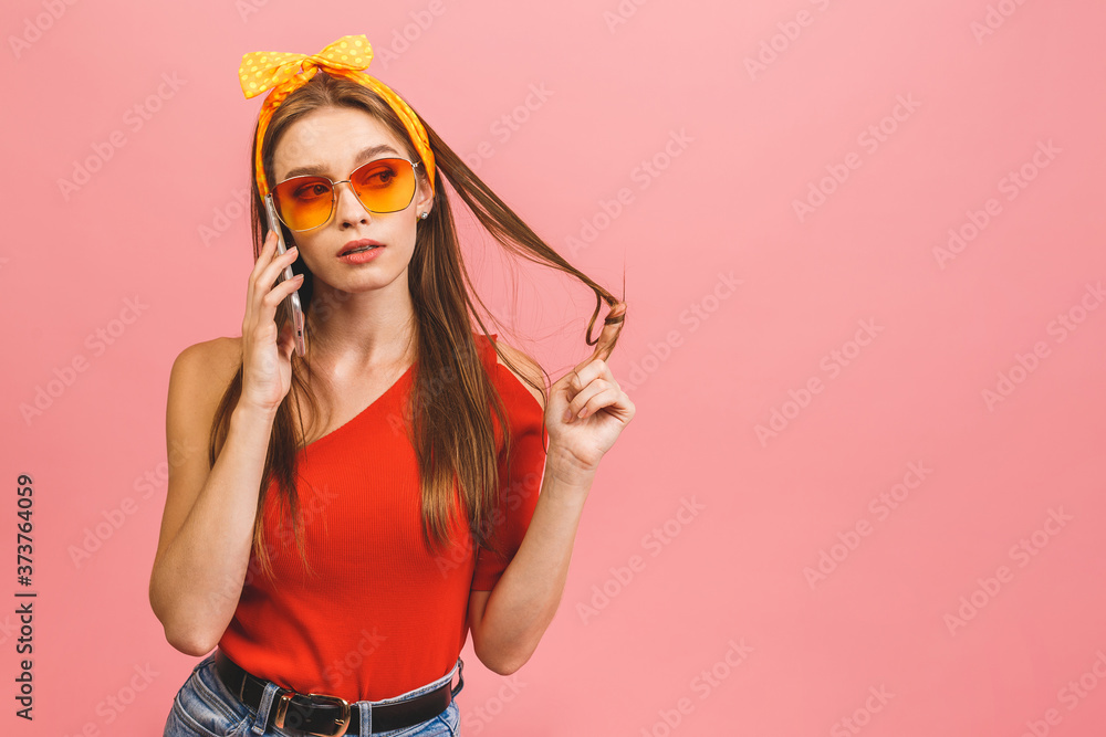 Portrait of a happy young business woman using mobile phone isolated over pink background.