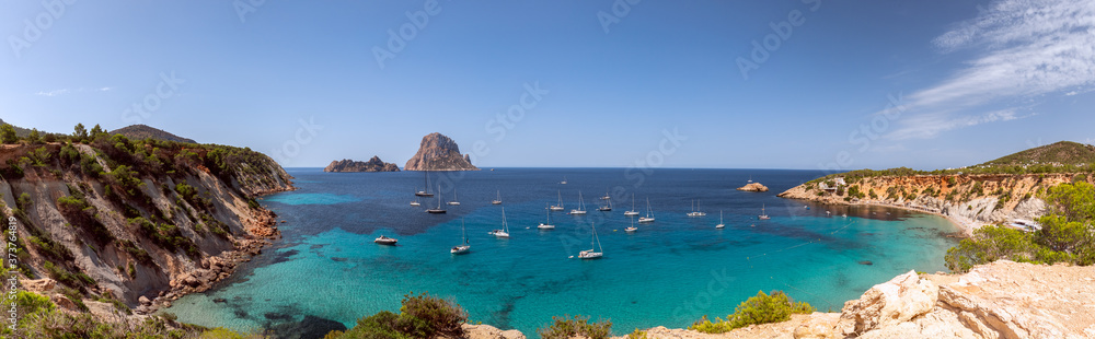 Panorama of beautiful bay Cala Hort with sea sailing yachts and the mountain Es Vedra. Ibiza, Balearic Islands, Spain