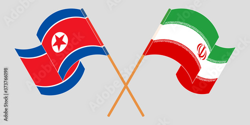 Crossed and waving flags of Iran and North Korea
