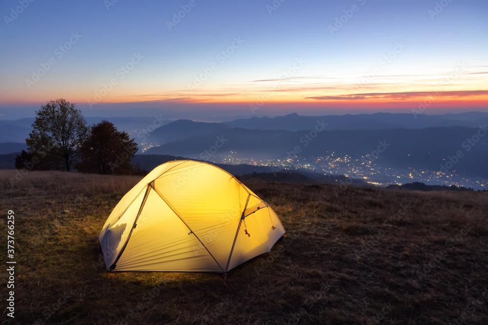 Night mountain landscapes. Tent stands on the lawn. Touristic camping rest place. Amazing sunrise. Location Carpathian, Ukraine, Europe.