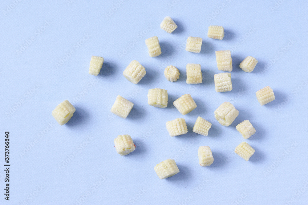 Frozen vegetables baby corn on a blue background with copy space. Top view. Horizontal orientation Frozen vegetables baby corn on a blue background with copy space. Top view. Horizontal orientation