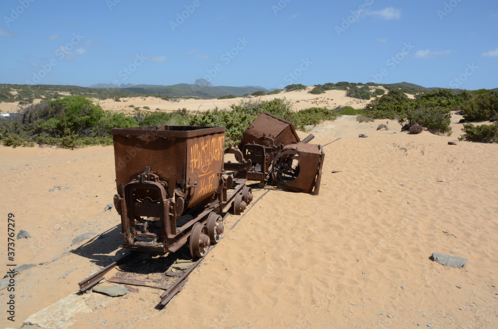 Obraz premium mine trolleys on sand dunes at piscinas, sardinia, italy