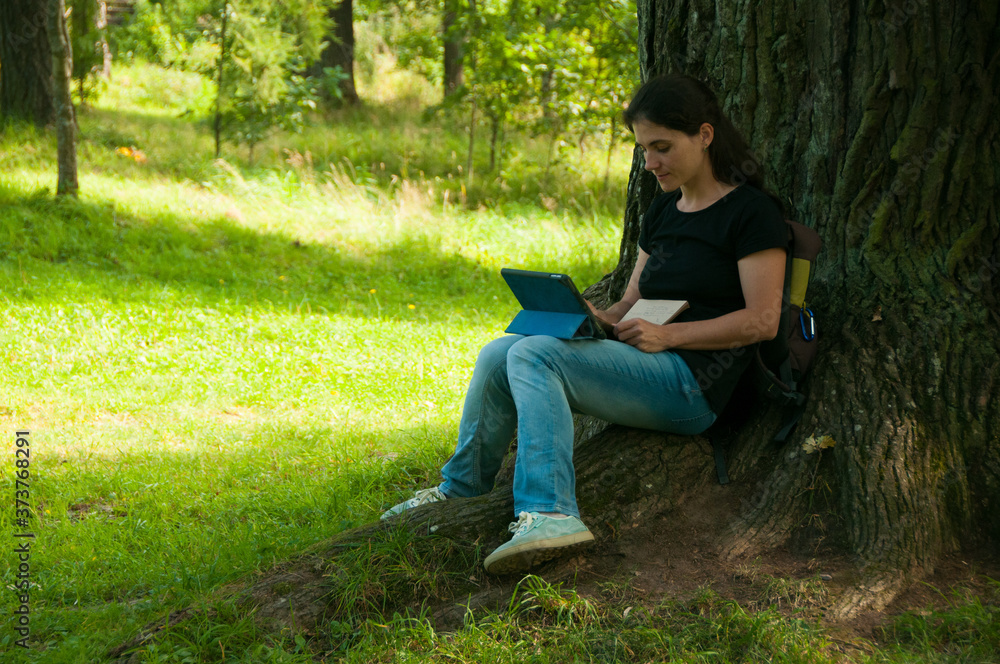 A girl studies online in a Park. Learning. Education. Using technology A girl studies online in a Park. Learning. Education. Using technology