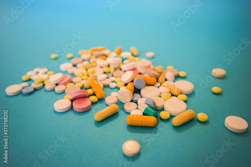 pills and capsules close up on a blue table
