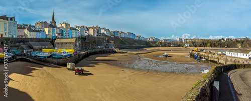A view across the harbour in Tenby, Pembrokeshire at low tide on a sunny day