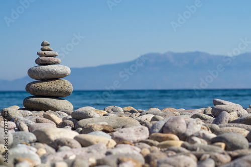 Balanced stones on a pebble beach during sunset