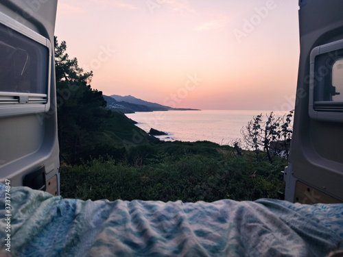 Canvas-taulu Beautiful view of a coast from the trunk of a campervan - a concept on traveling