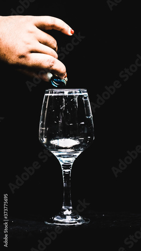 adding essence into a cup of water in a wineglass.