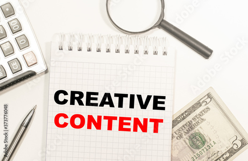 text BE CREATIVE CONTENT written on notepad with calculator, pensil, magnifier and dollars. Business concept