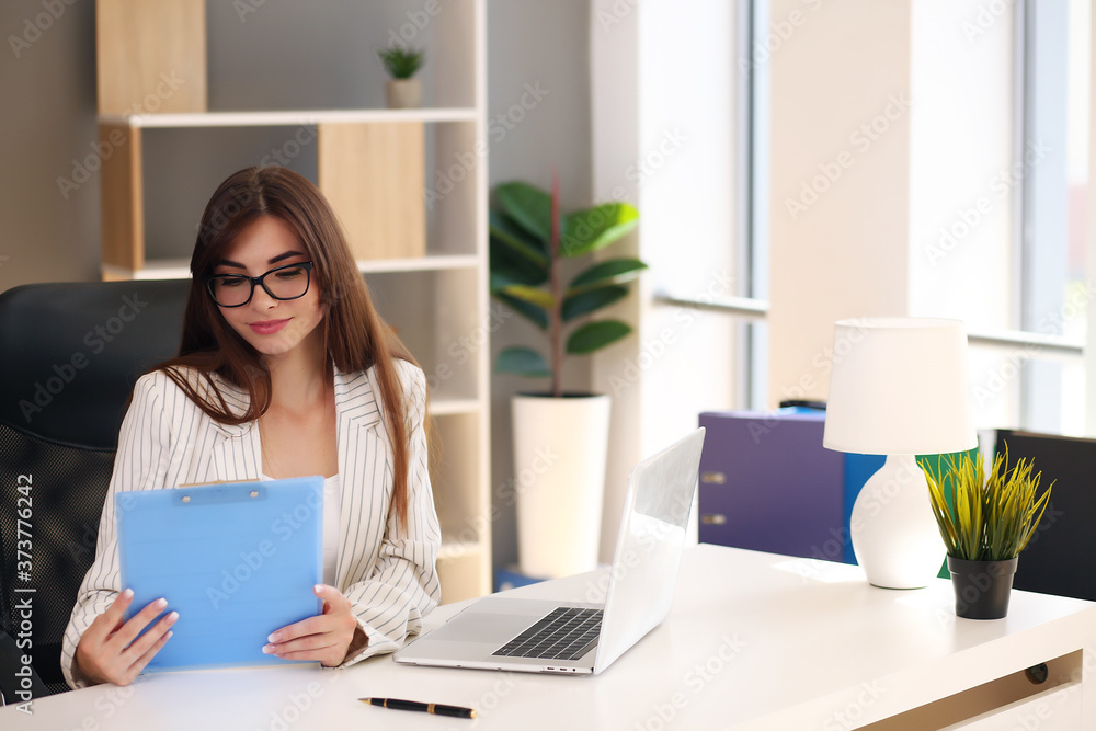 Young business woman working in her office using a laptop Young business woman working in her office using a laptop