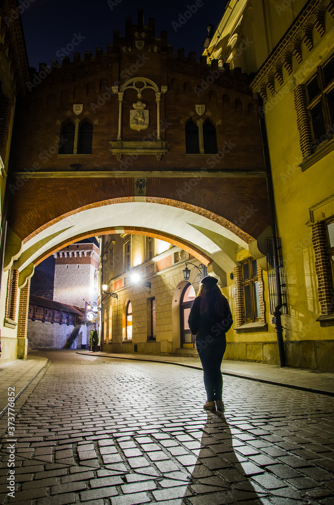 Woman walking in the night, Cracow, Poland