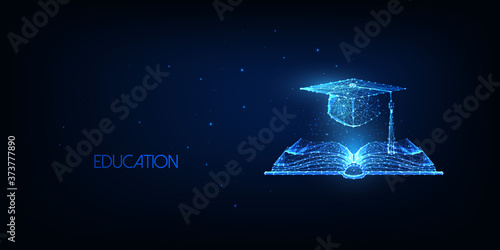 Futuristic education concept with glowing low polygonal open book and graduation cap photo
