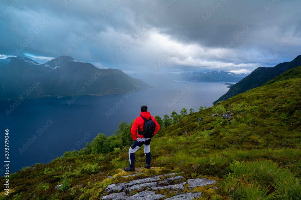 Fototapeta premium Hiker standing on top of the mountain on a foggy day