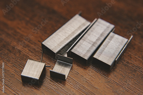 metal staples on wooden background