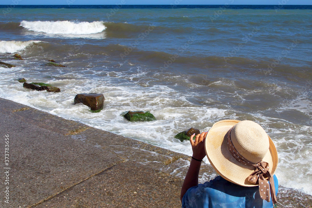 Vacation by the sea. Girl in a hat on the sea beach Vacation by the sea. Girl in a hat on the sea beach