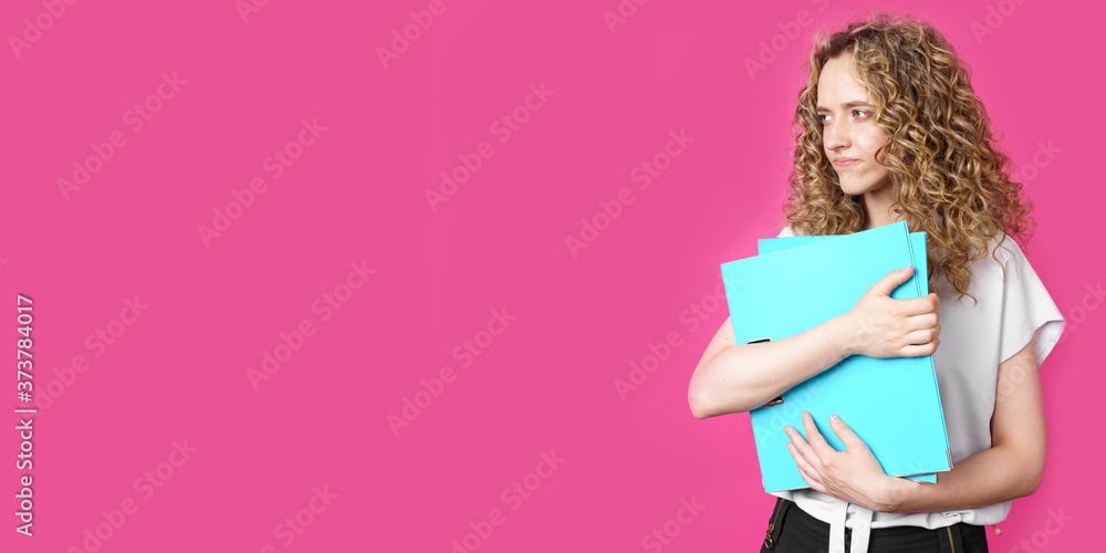 A young woman holds folders with documents in her hands.