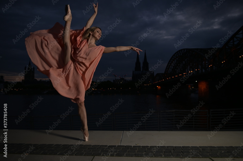 A beautiful ballet dancer ballerina outdoors ,Ballerina dancing on the bridge in Cologne City . A beautiful ballet dancer ballerina outdoors ,Ballerina dancing on the bridge in Cologne City .