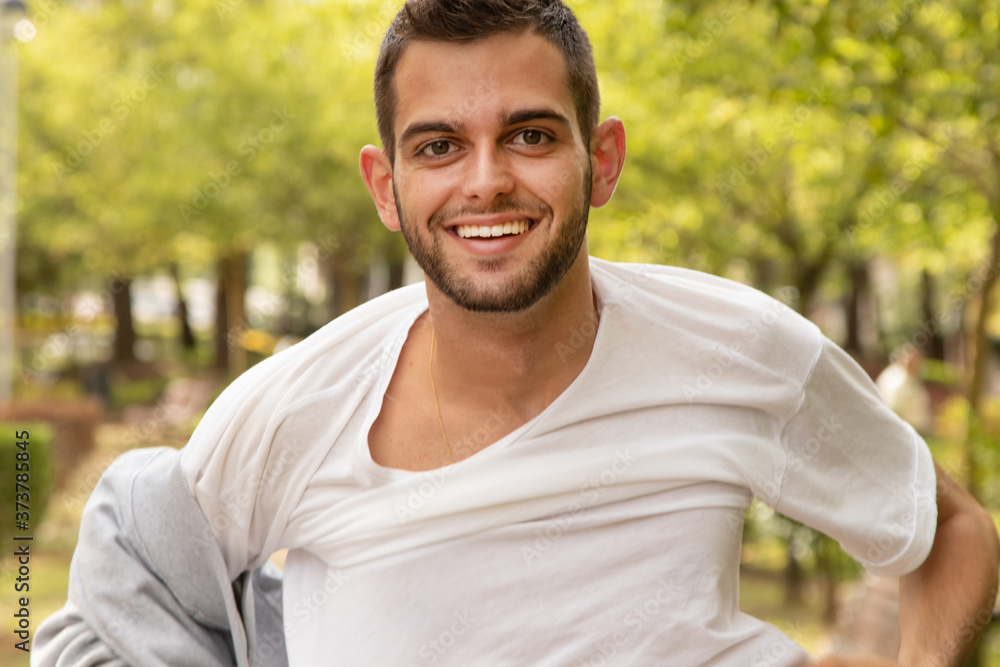 portrait of young man outdoors taking off his sweater portrait of young man outdoors taking off his sweater