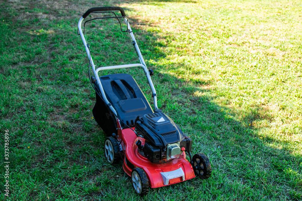 lawn mower on the grass with copy space, agricultural and gardening machinery lawn mower on the grass with copy space, agricultural and gardening machinery
