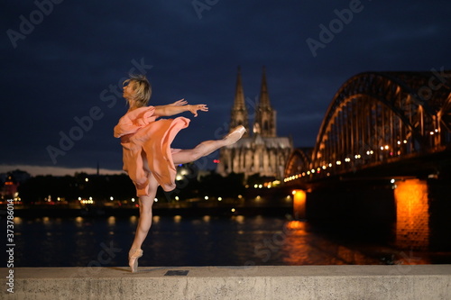Photography A beautiful ballet dancer ballerina outdoors ,Ballerina dancing on the bridge  in Cologne City